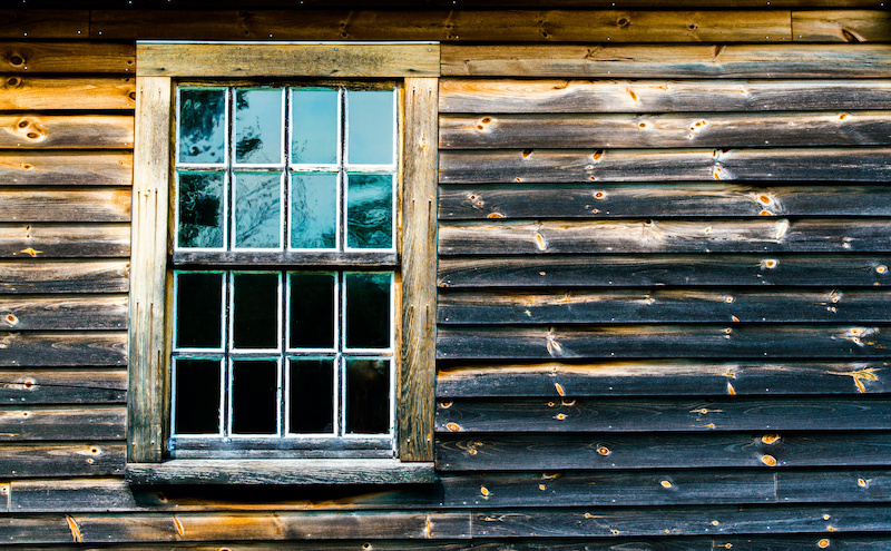 weathered wooden wall with window in colonial building